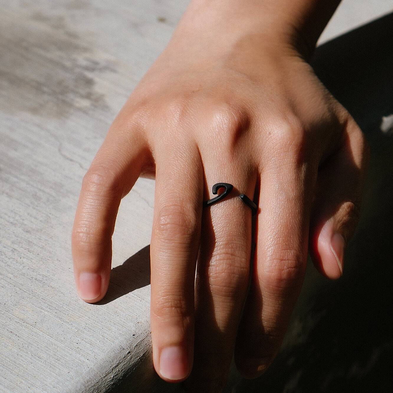 Hydra stainless steel black PVD ring with single curved oval loop worn on finger