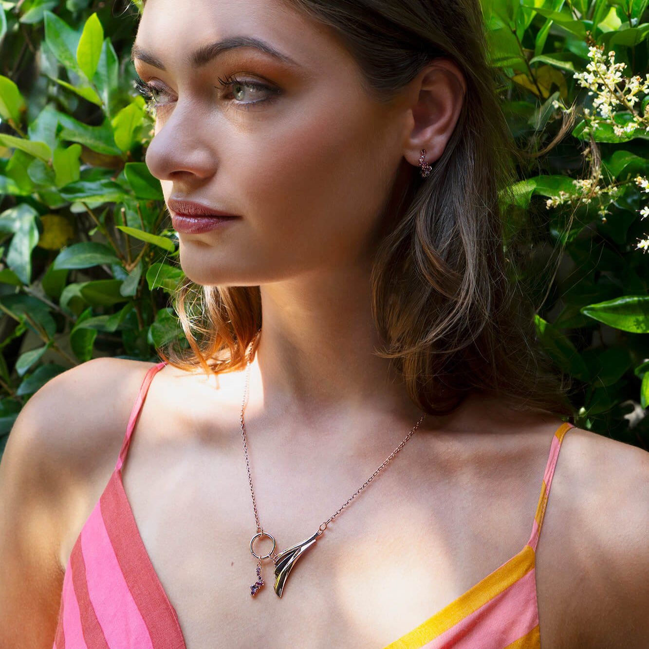 Woman wearing Leda gemstone necklace in 18K rose gold vermeil with amethyst and pink tourmaline accents outdoors