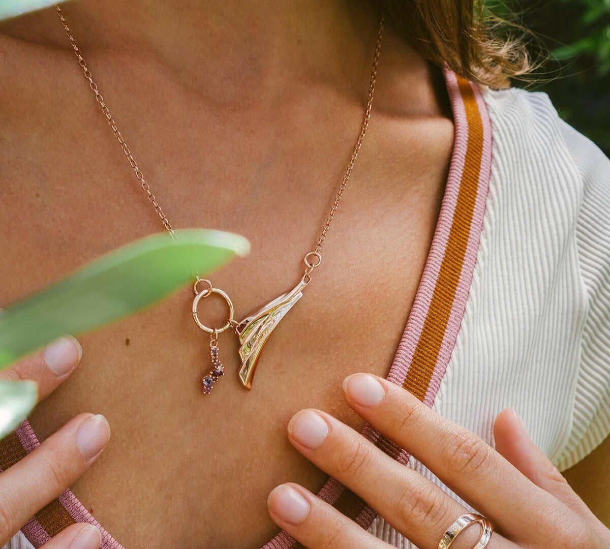 Close-up of Leda gemstone necklace in 18K rose gold vermeil with amethyst and pink stones worn on model's neck