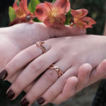 Amor Amos Light Set with stackable rose gold rings on hands with flowers background