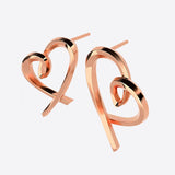 Close-up of elegant heart studs earrings in sterling silver with lace detailing on grey background