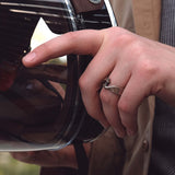Hand wearing Machina Gift Set ring with 3D printed stainless steel and mechanical design adjusting a motorcycle helmet