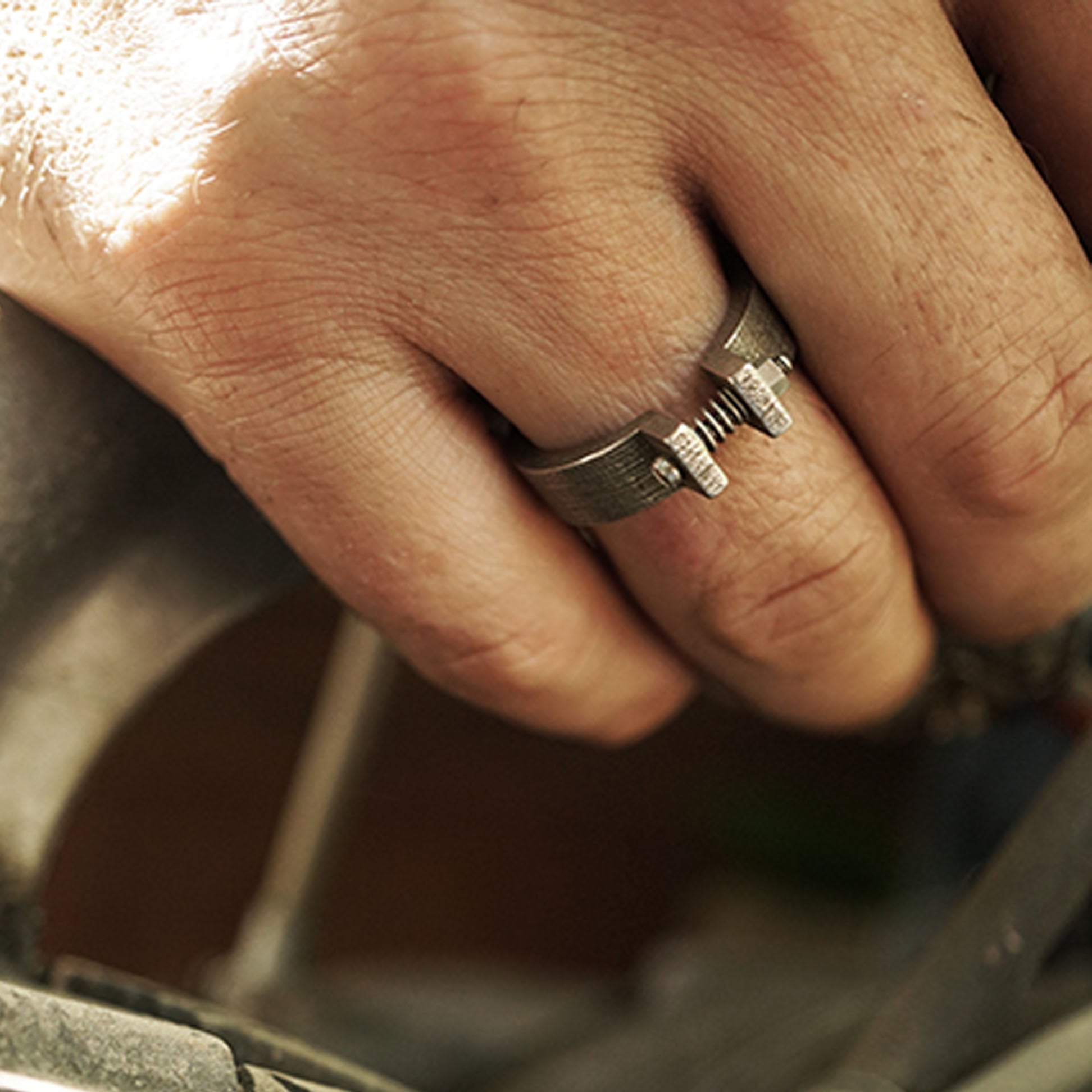 Close-up of a hand wearing a Machina Gift Set men's 3D printed stainless steel ring with machined hardware details