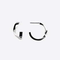 Close-up of silver Linea Mini Hoop earrings with open twisting band design on white background