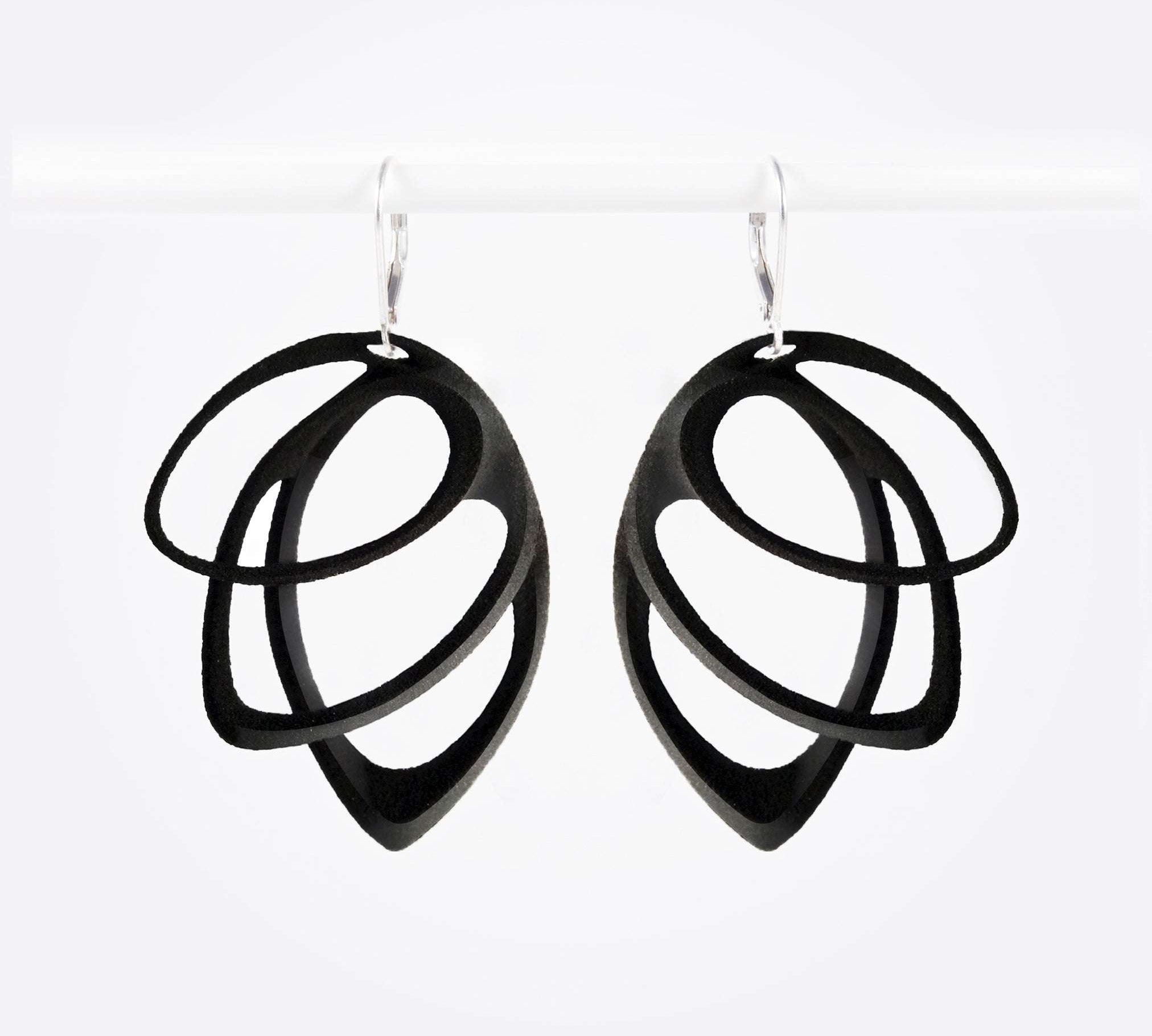 Black polished Orbis Nylon Earrings with three elliptical open loops in descending sizes, hanging on silver hooks