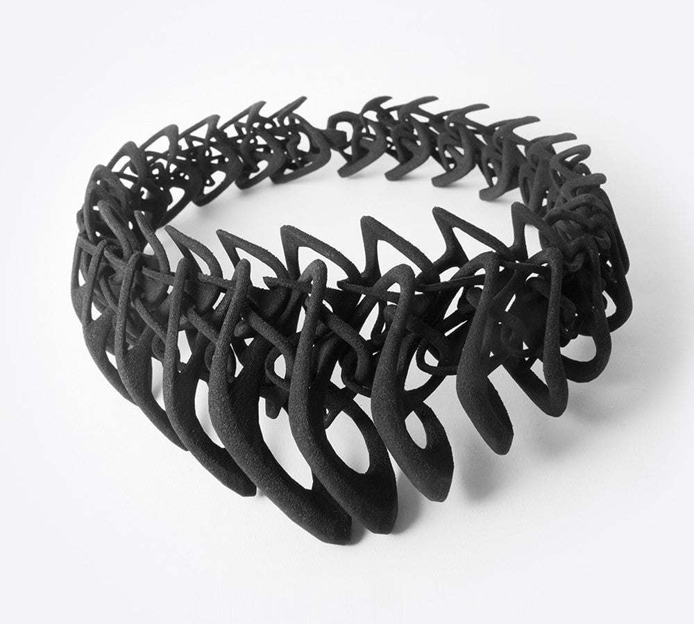 Black 3D printed TPU necklace with interlocking elliptical petals design forming a layered, flexible structure